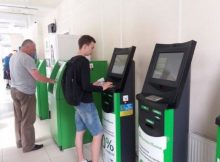 Молодой человек погашает кредит через терминал Приватбанка